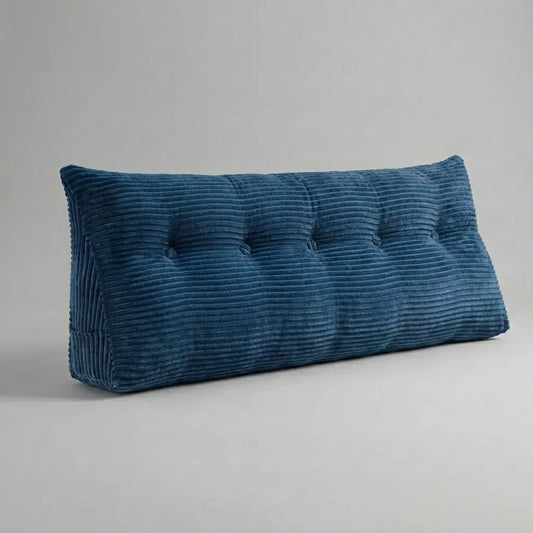Coussin tête de lit triangulaire en velours côtelé beige posé sur un lit