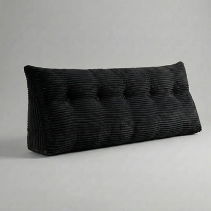 Coussin tête de lit triangulaire en velours côtelé noir posé sur un lit